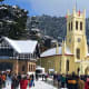 Christ Church Shimla with snow-covered timber-framed buildings and tourists in the town square during winter