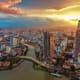 Aerial view of Ho Chi Minh City skyline at sunset with Bitexco Financial Tower and Saigon River winding through the cityscape