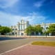 Penang Town Hall, a grand white colonial building with clock tower and manicured gardens, under blue sky