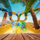 Multiple colorful water slides at Yas Waterworld theme park with palm trees and clear blue sky