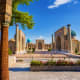 Registan square in Samarkand, Uzbekistan featuring three grand madrasahs with blue domes and intricate tilework under clear b