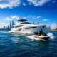 Luxury white yacht with jet skis in Dubai waters, city skyline and Ferris wheel visible in background