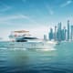 Luxury white motor yacht cruising in turquoise waters with modern skyscrapers and city skyline in background