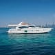 White luxury motor yacht anchored in turquoise water with Dubai skyline in background