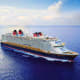 Large Disney cruise ship sailing on open blue ocean under partly cloudy sky