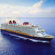 Large modern cruise ship sailing on open blue ocean water with white clouds in sky