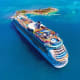 Aerial view of large cruise ship anchored in turquoise waters near tropical island resort