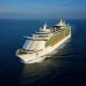 Large modern cruise ship sailing on calm blue ocean water under clear sky