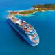 Aerial view of Navigator of the Seas cruise ship anchored near a tropical island in turquoise blue waters