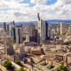 Aerial view of Frankfurt skyline with Main Tower and surrounding skyscrapers against cloudy blue sky
