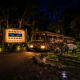 Night Safari tram passing elephants at illuminated entrance sign in Singapore wildlife park