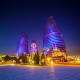 Modern illuminated towers with blue and purple LED lighting at night in Baku, Azerbaijan