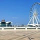 White Ferris wheel and modern architectural structures on waterfront promenade in Baku, Azerbaijan under blue sky