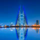 Bahrain skyline at dusk with illuminated Bahrain World Trade Center twin towers reflected in still water