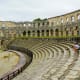 Roman amphitheater ruins in Pula, Croatia with stone arches and seating tiers surrounded by ancient walls