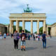 Tourists gathering at Brandenburg Gate in Berlin, Germany with classical stone columns and chariot sculpture on top