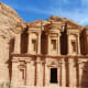 The Monastery at Petra, a massive carved sandstone temple facade with ornate columns and capitals set into a desert cliff fac