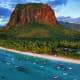 Aerial view of Le Morne Brabant mountain with turquoise lagoon, sandy beach, and moored boats in Mauritius