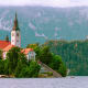 Church of the Assumption on an island in Lake Bled, Slovenia, surrounded by forested mountains and cliffs