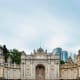 Ornate white stone palace gate with detailed architectural carvings and turrets, Dolmabahce Palace in Istanbul, Turkey