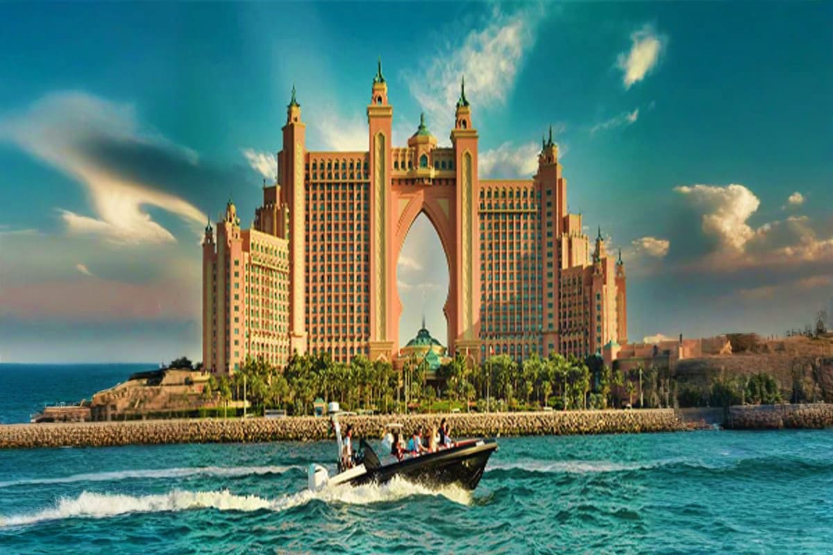 Black Boat Tours Black boat with tourists approaching Atlantis The Palm hotel in Dubai with turquoise ocean and sandy beach