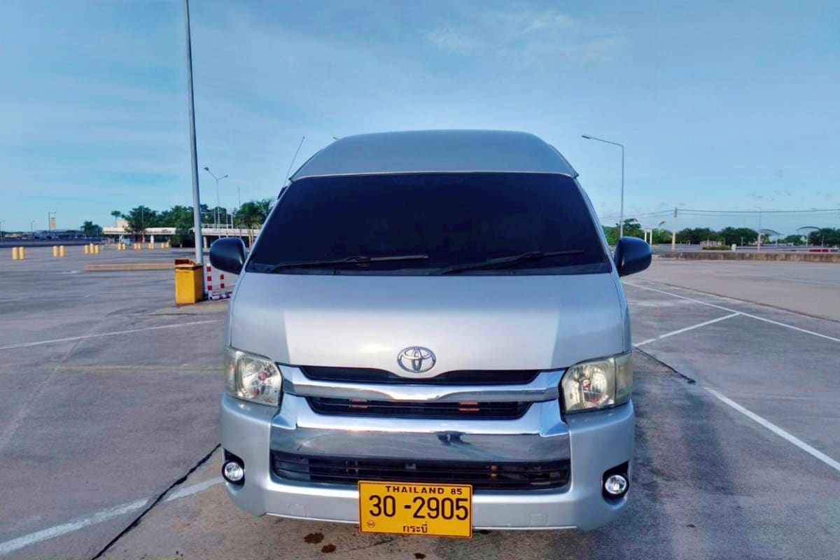 Samui Hotel to Na Thorn Pier White Toyota van with Thailand license plate parked in empty lot, front view for Samui Hotel to Na Thorn Pier transfer servic
