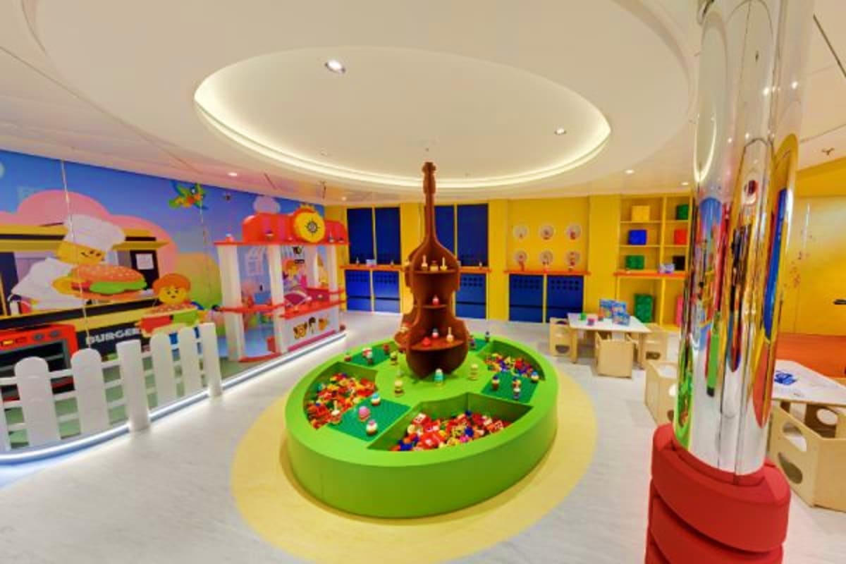 Colorful modern children's playroom on MSC Euribia cruise ship with ball pit, interactive games, and bright yellow walls