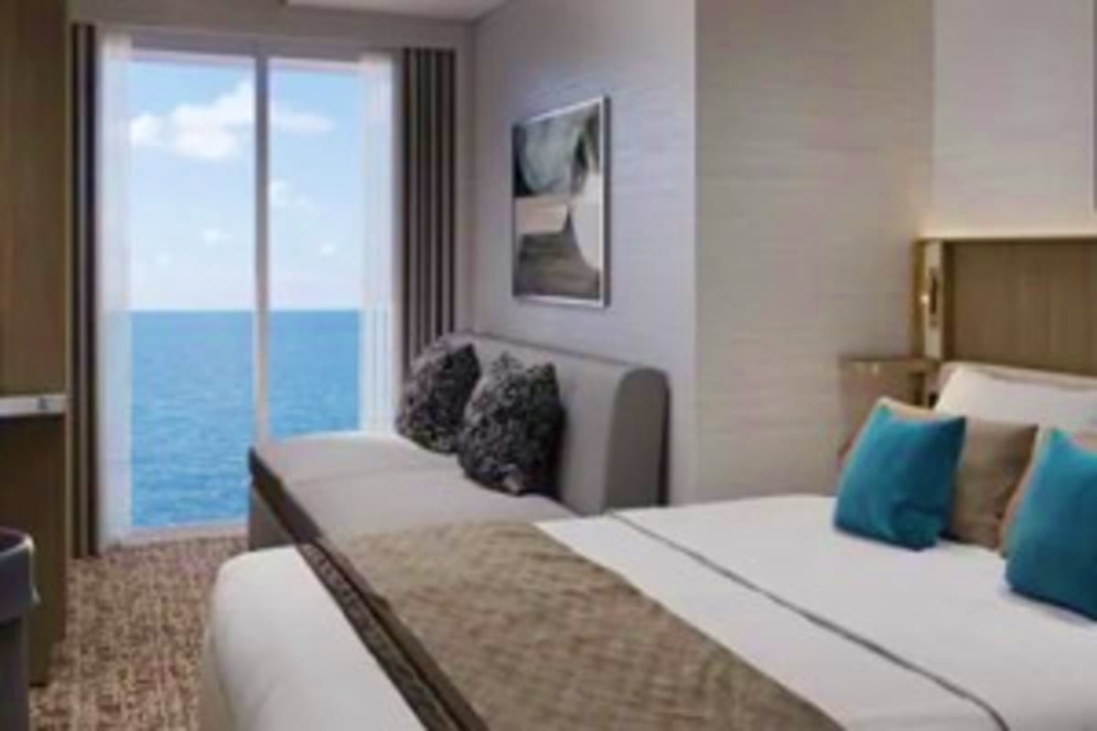 Modern cruise ship stateroom with oceanview balcony overlooking blue Mediterranean Sea waters and sky
