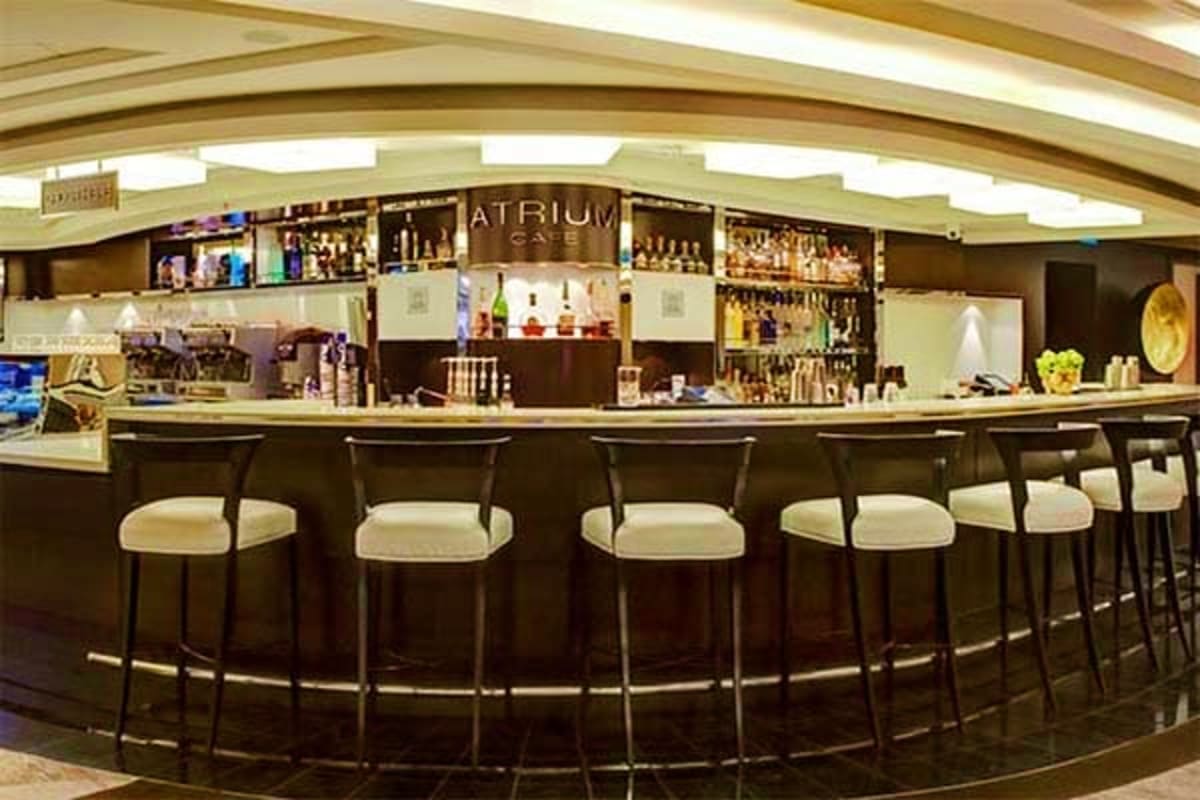 Atrium Cafe bar counter with curved seating and stocked shelves on Norwegian Epic cruise ship