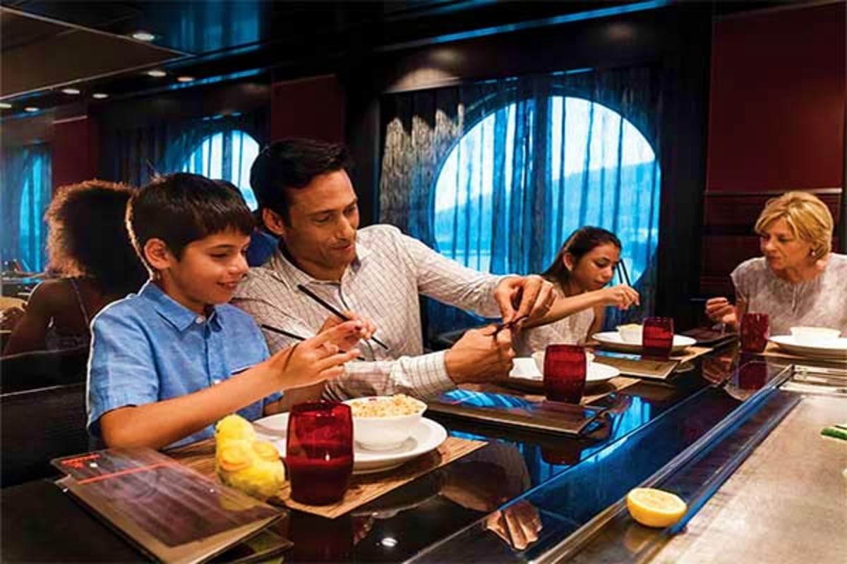 Family dining at restaurant counter on Royal Caribbean cruise ship with ocean view windows