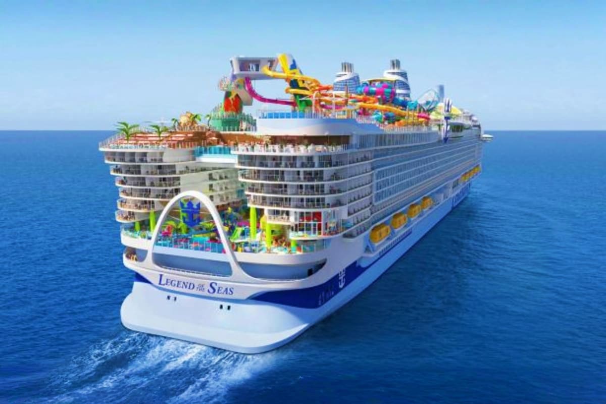 Legend of the Seas cruise ship with water slides and pools visible on deck, sailing on blue ocean water