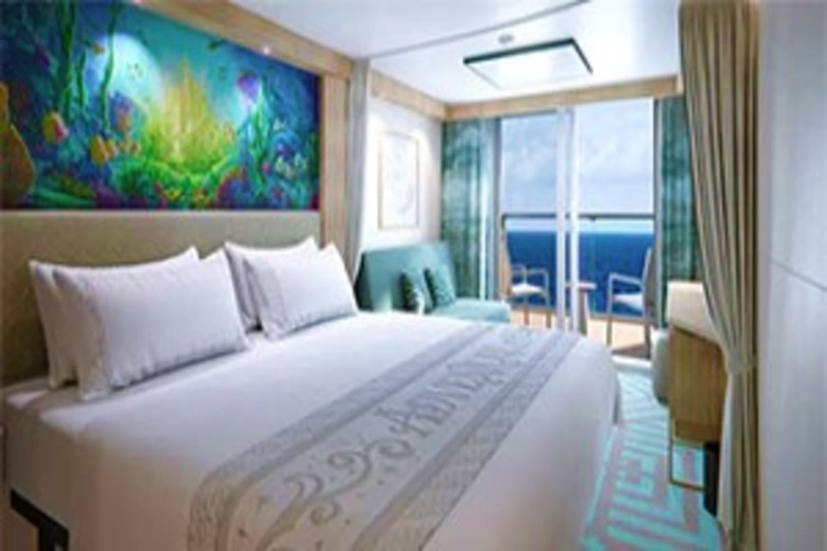 Modern cruise ship cabin with queen bed, ocean view balcony, colorful artwork above headboard, and floor-to-ceiling curtains