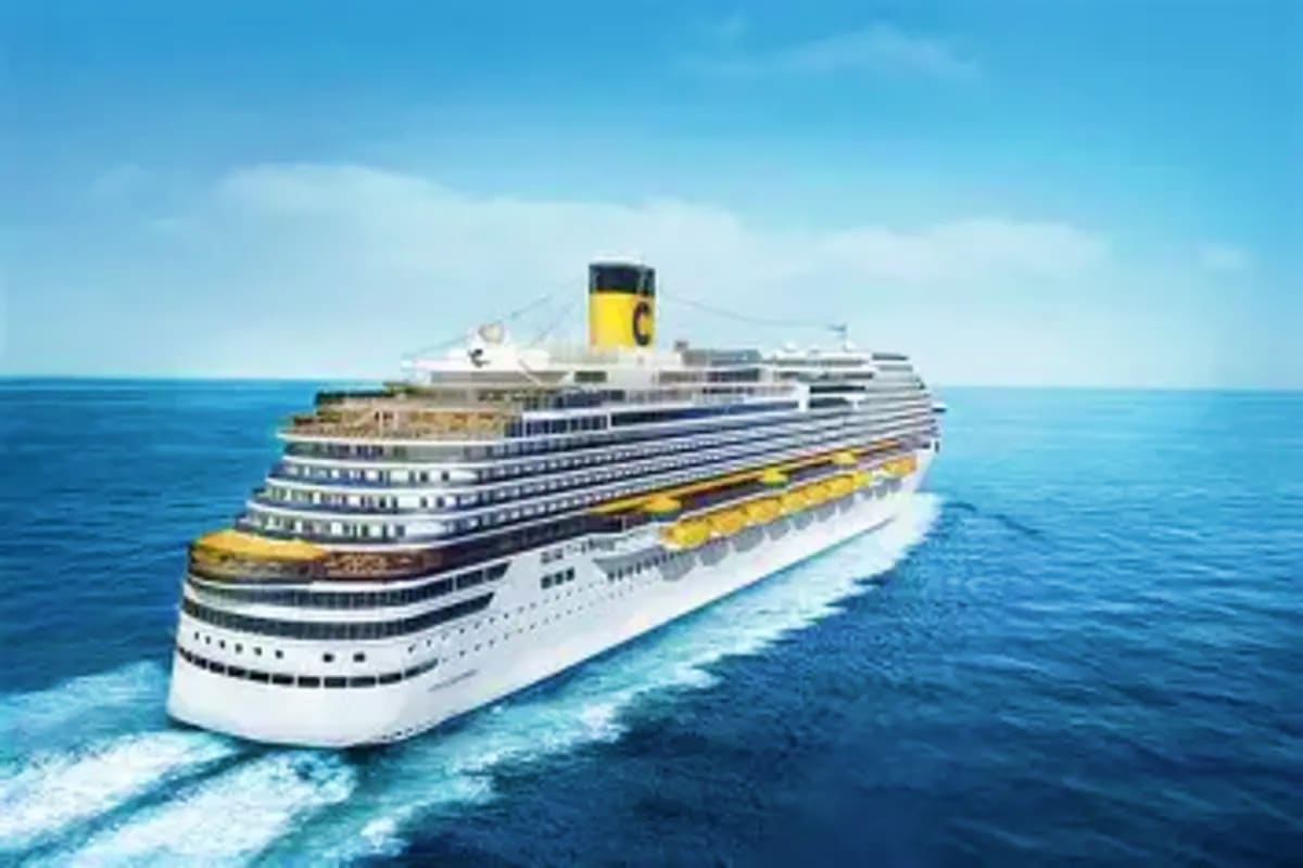 Large white cruise ship with yellow funnel sailing on blue ocean under clear sky