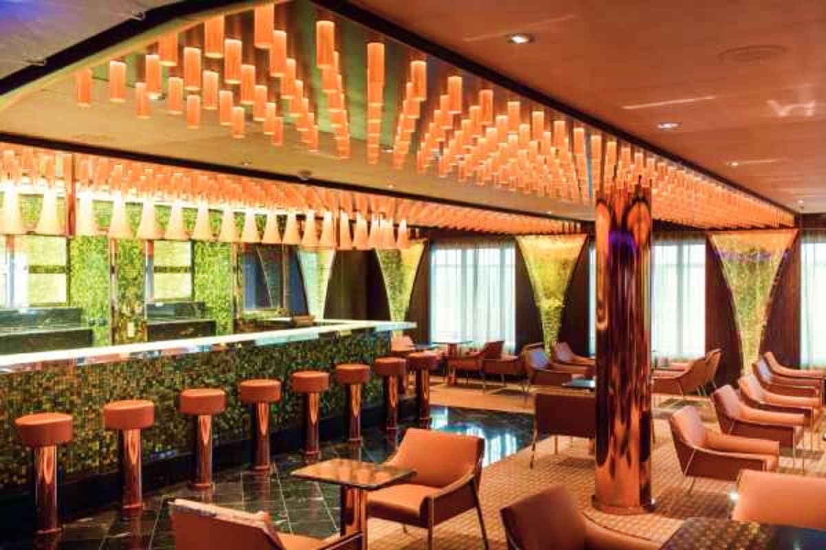 Modern cruise ship lounge with orange pendant lighting, bar seating, green moss wall panels, and contemporary furniture overl