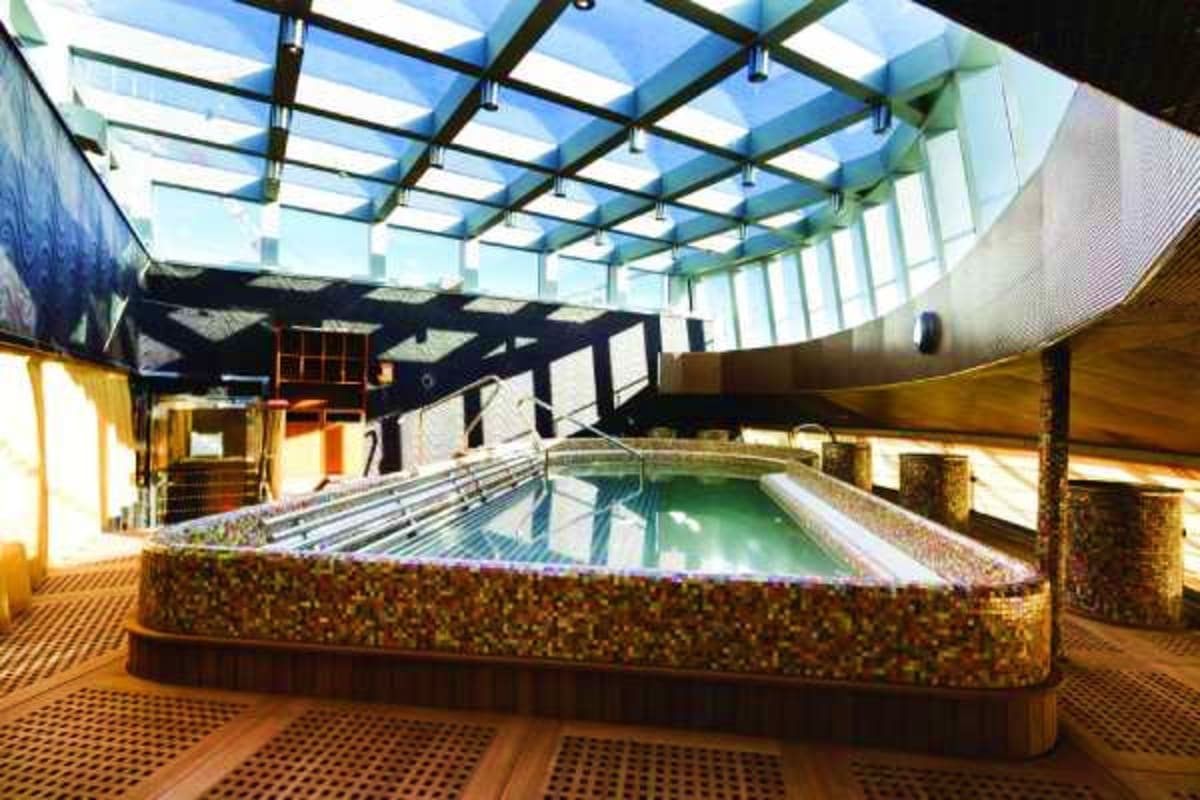Indoor swimming pool with glass ceiling on Diadema ship, showing mineral-tiled pool and modern architectural design