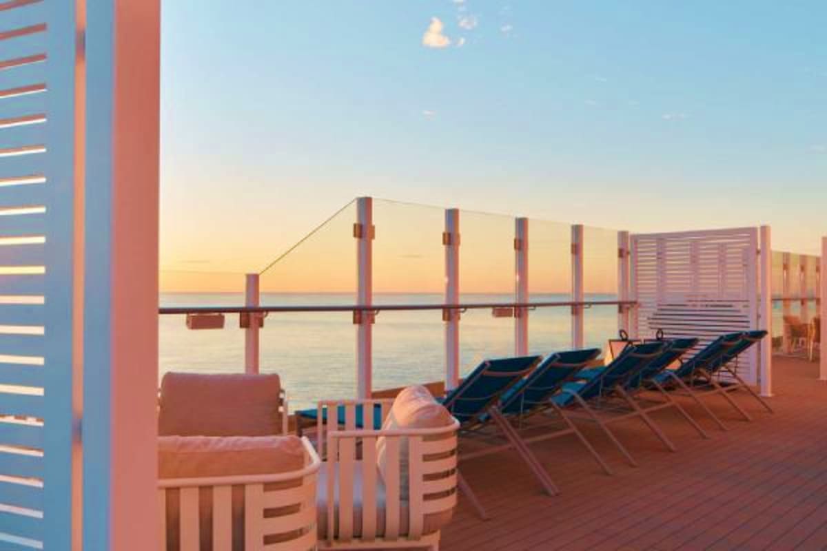 Costa Toscana Western Mediterranean Cruise Cruise ship deck at sunset with lounge chairs, striped cabanas, and calm Mediterranean sea at golden hour
