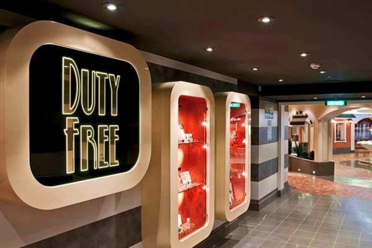 Duty Free shop storefront with neon signage in modern airport or cruise terminal corridor with red display windows