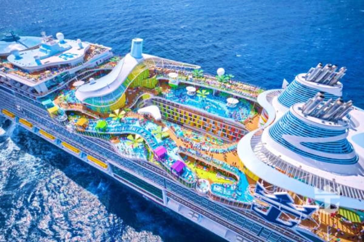Aerial view of Royal Caribbean cruise ships docked in blue Caribbean waters with multiple pools and water slides visible on d