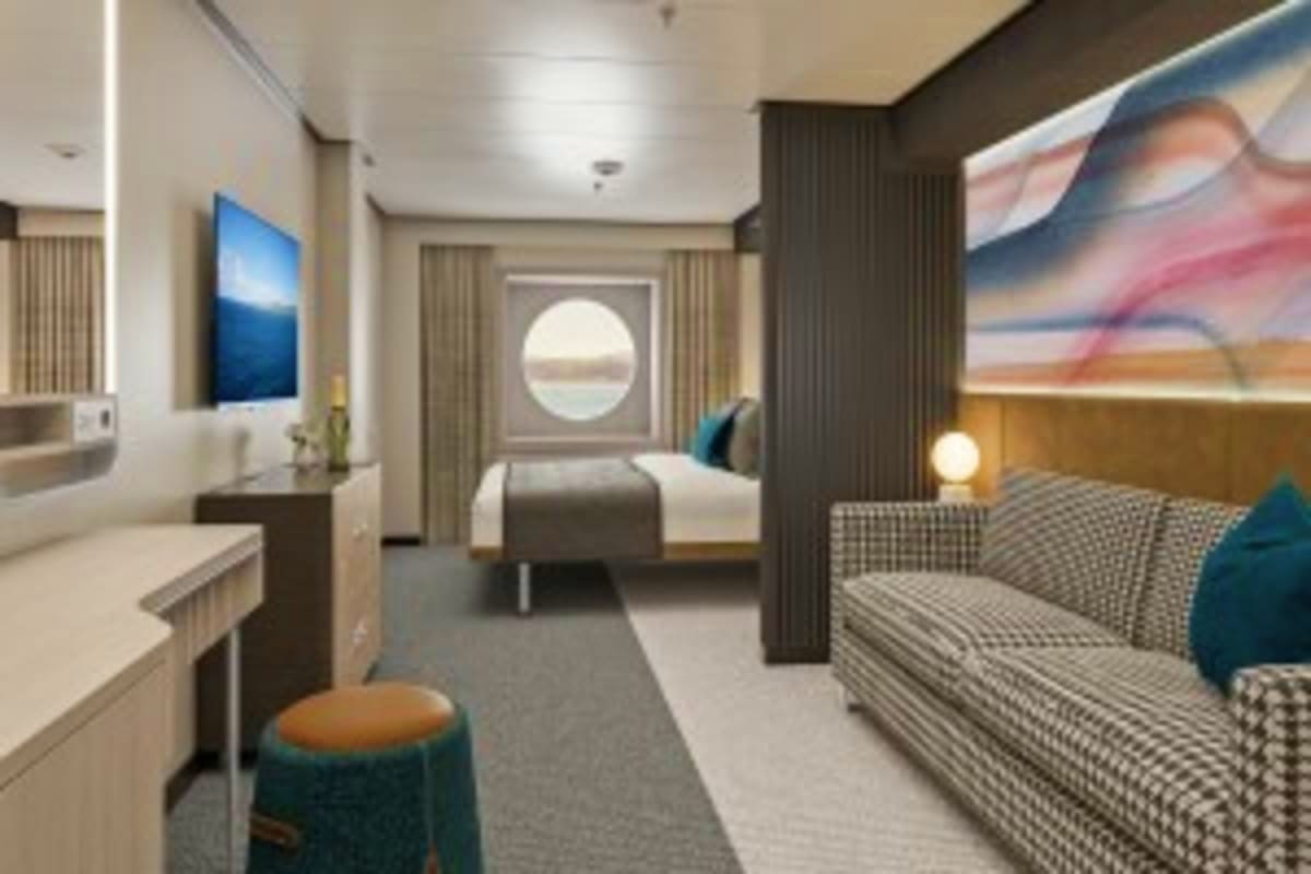 Modern cruise ship cabin interior with bed, sofa, desk, porthole window, and neutral decor in gray and beige tones