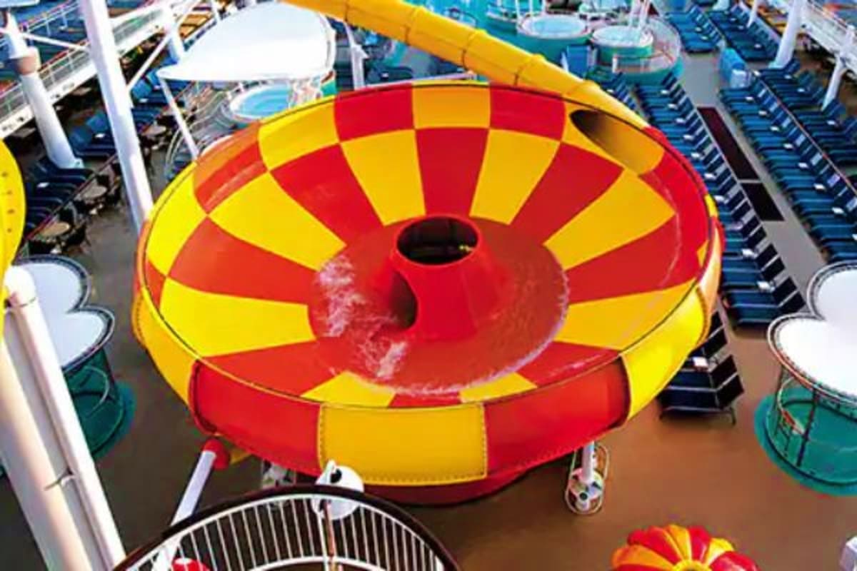 Overhead view of red and yellow inflatable water slide on cruise ship deck with lounge chairs and ocean features