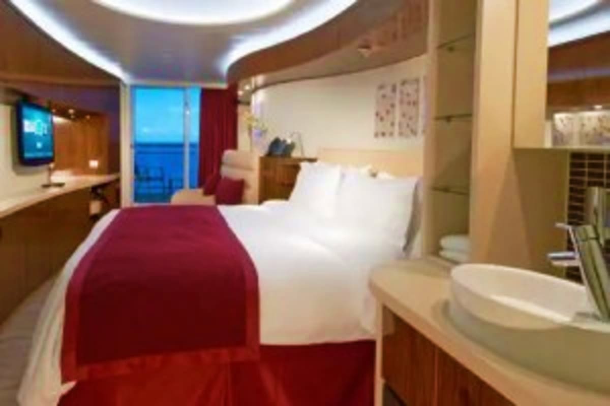 Norwegian Epic Southern Europe Cruise Luxurious cruise ship cabin with ocean view, queen bed with burgundy throw, white linens, flat-screen TV, and modern bathroom