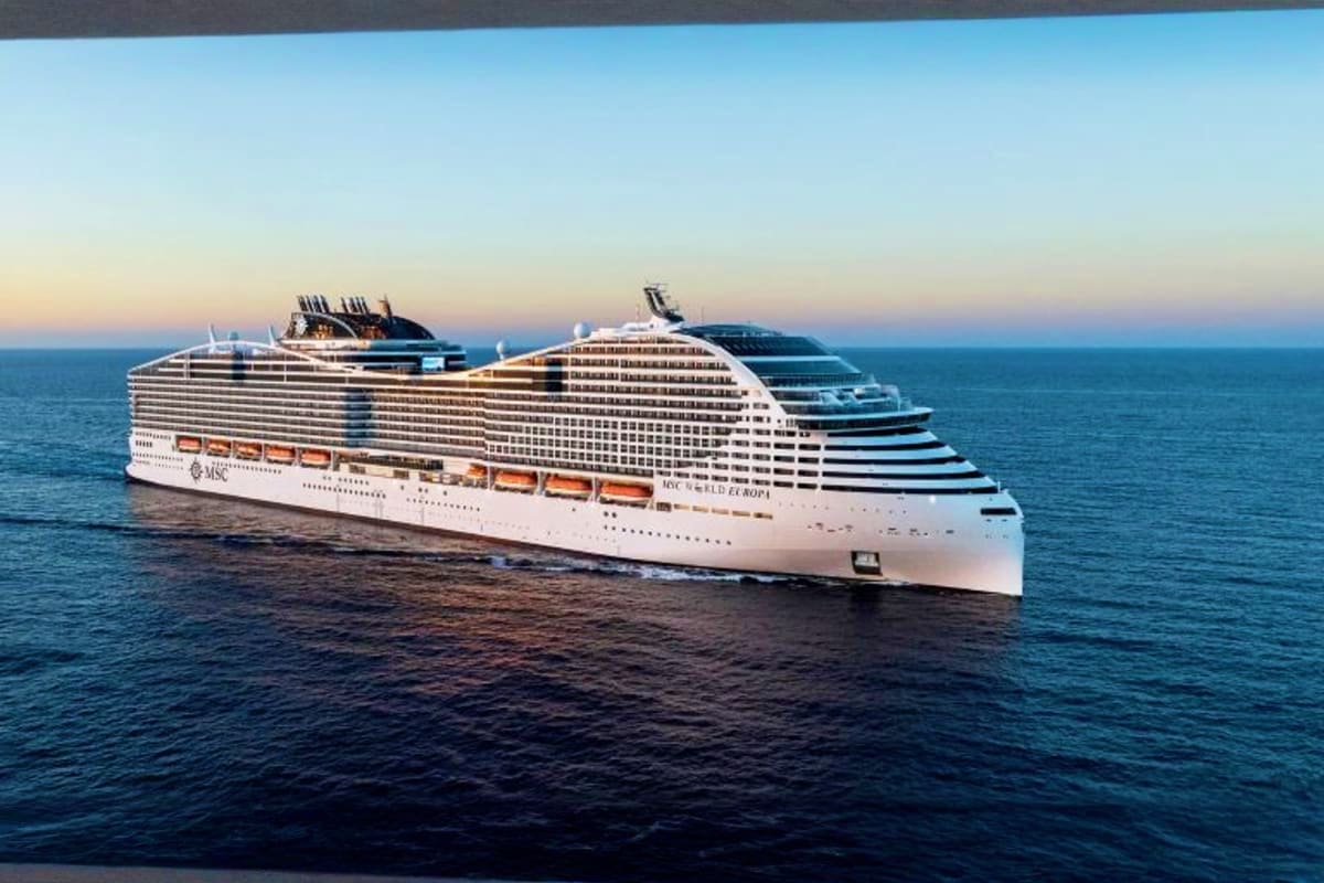 MSC World Europa Barcelona Roundtrip Cruise Large white MSC cruise ship sailing on calm blue ocean water at sunset with clear sky
