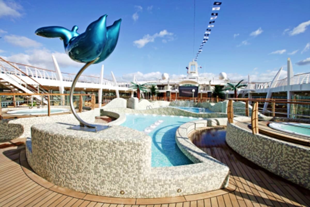 MSC Fantasia Eastern Mediterranean Cruise MSC Fantasia ship deck water park featuring turquoise dolphin sculpture and swimming pools under blue sky