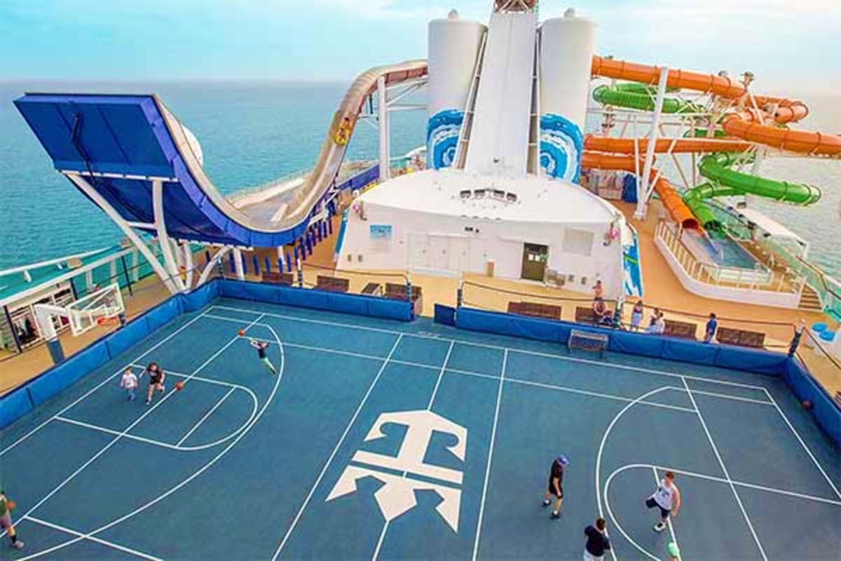 Liberty of the Seas cruise ship deck with basketball court, water slides, and ocean view in background