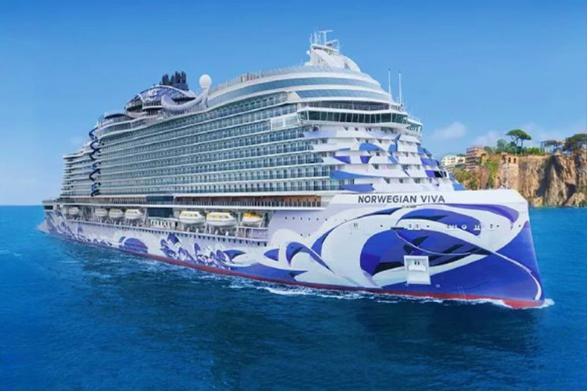 Norwegian Cruise Line Greek Islands Cruise Norwegian Viva cruise ship sailing in blue Mediterranean waters near a rocky cliff coastline