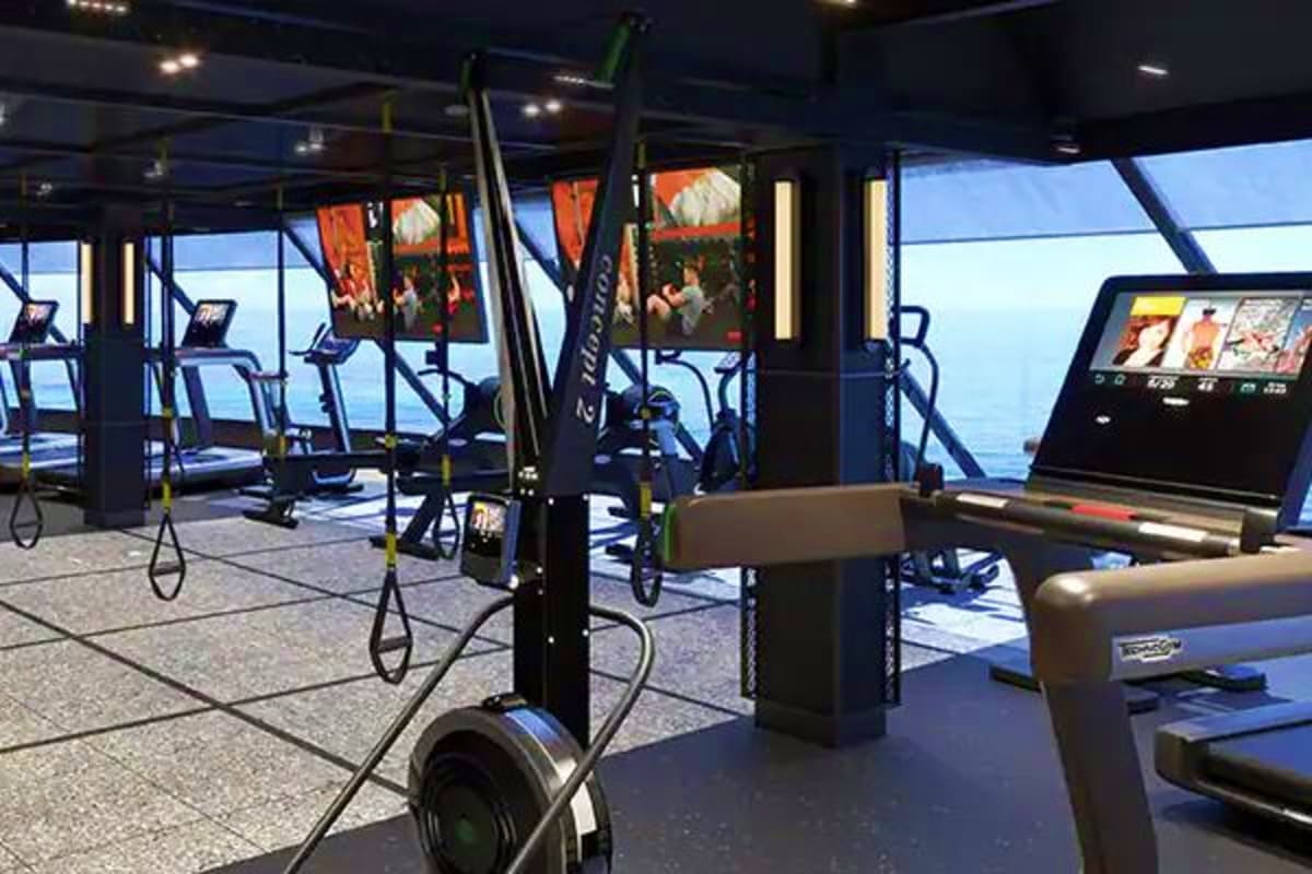 Norwegian Cruise Line Greek Islands Cruise Modern gym interior on cruise ship with cardio equipment, treadmills, and ocean view through large windows