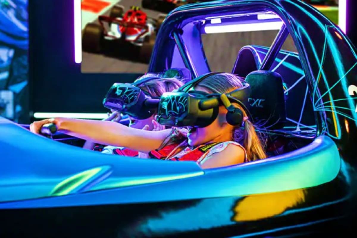 Norwegian Cruise Line Greek Islands Cruise Player in neon-lit virtual racing simulator cockpit with purple and blue LED lighting and gaming controls