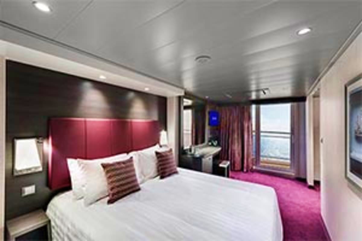 Luxury cruise ship cabin with queen bed, burgundy headboard, purple carpet, ocean view balcony, and modern amenities