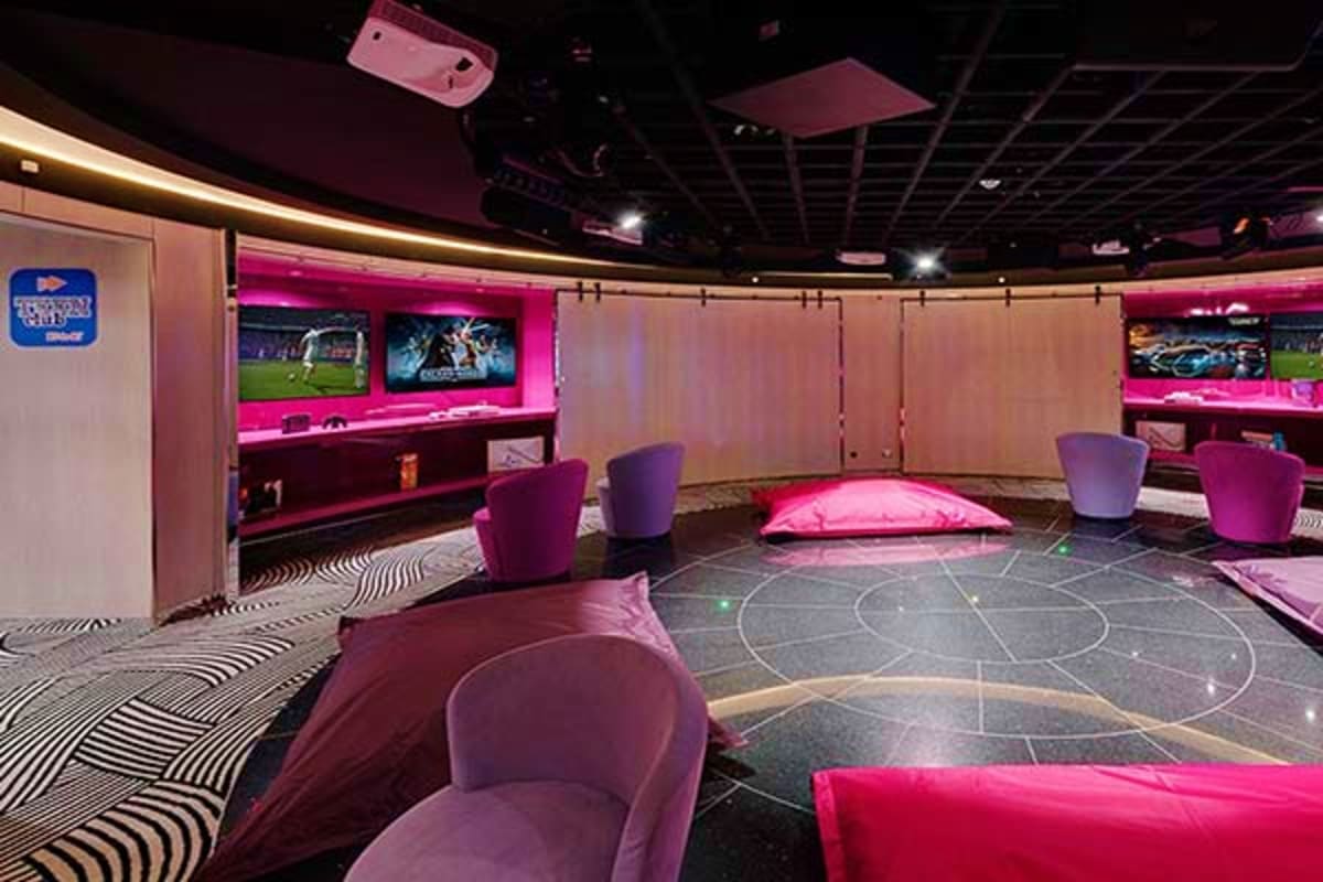 Modern nightclub interior with pink neon lighting, curved seating, multiple TV screens, and geometric floor patterns on MSC G