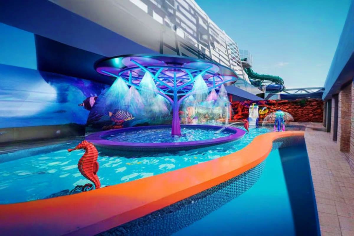 MSC World Europa Mediterranean Cruise Modern indoor aquatic center with vibrant blue pools, colorful seahorse sculptures, illuminated purple canopy structure, and